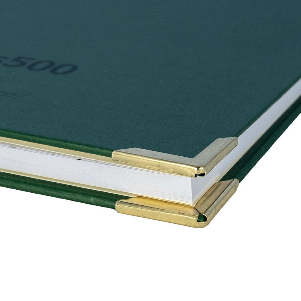 Grünes Buch mit goldenen Metall-Buchecken am Einband