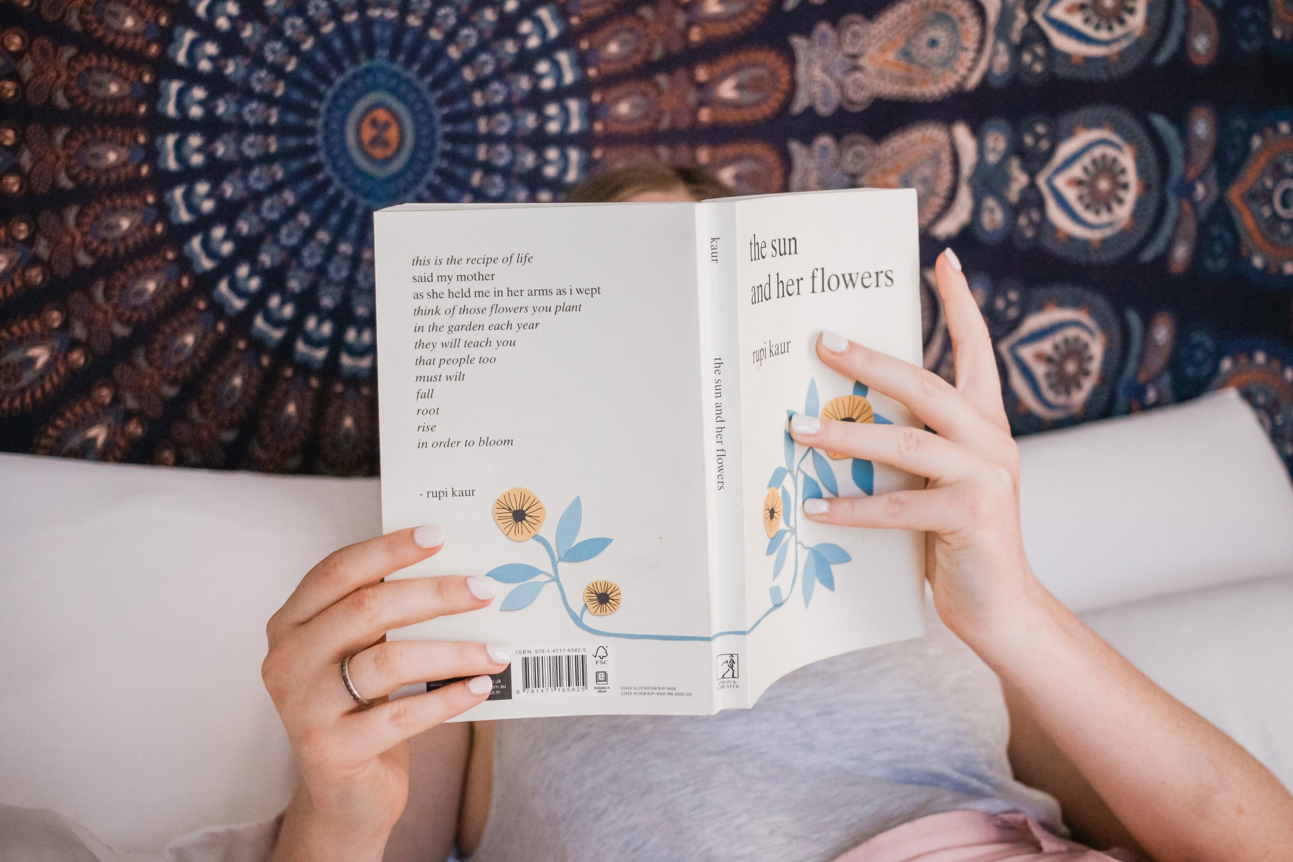 Frau liest Taschenbuch im Bett